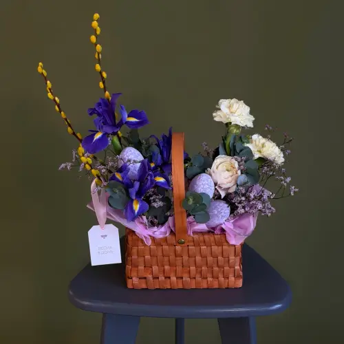 Цветочная композиция из ирисов, вербы и гвоздики в плетеной корзине